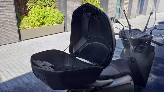 Detailný záber na otvorený inteligentný horný kufor modelu Honda SH350i. 