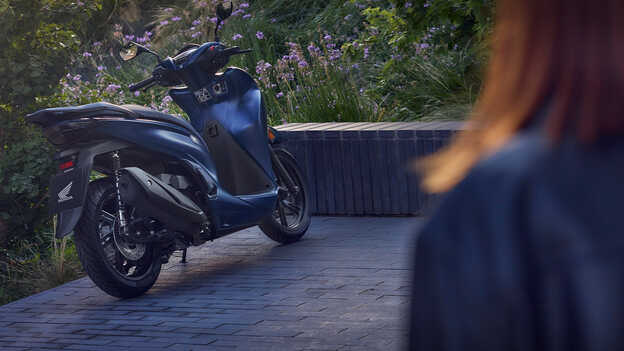 Pohľaa zozadu na model Honda SH350i v záhrade. 