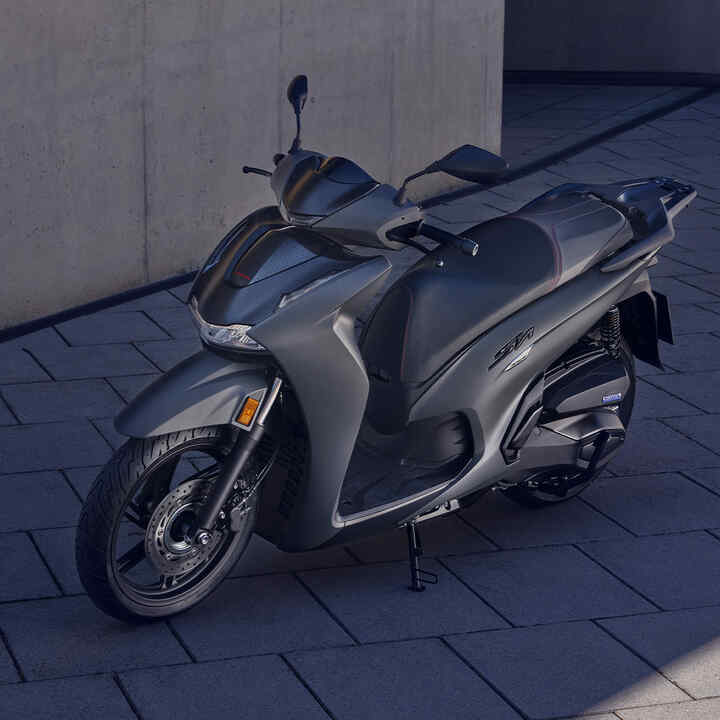 Trojštvrťový záber spredu na model Honda SH350i na nádvorí.