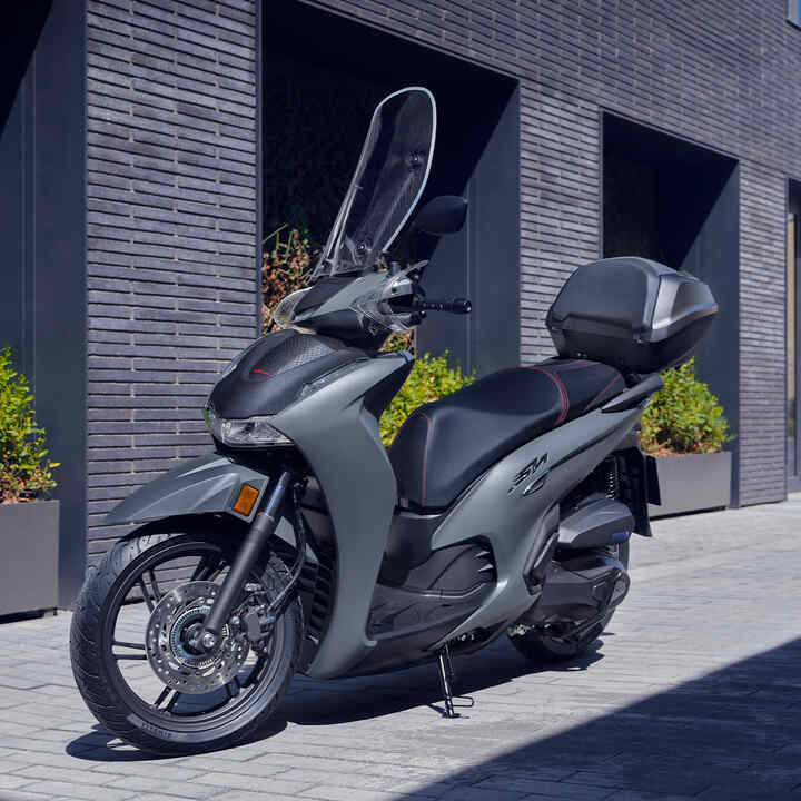 Trojštvrťový záber spredu na model Honda SH350i v zastavanej oblasti.